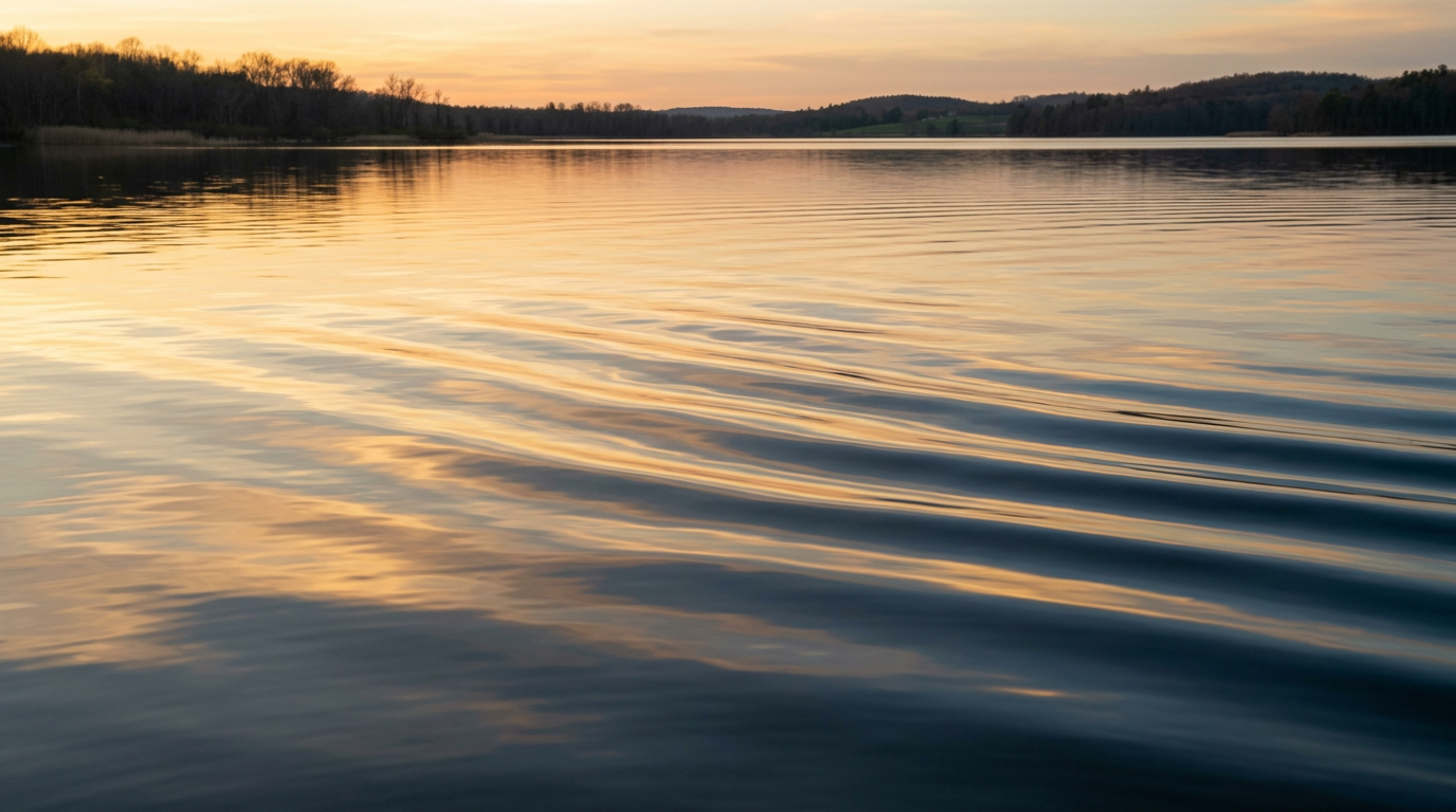 Calm abstract waves of light reflecting on water in warm tones, representing structured and hopeful alcohol recovery